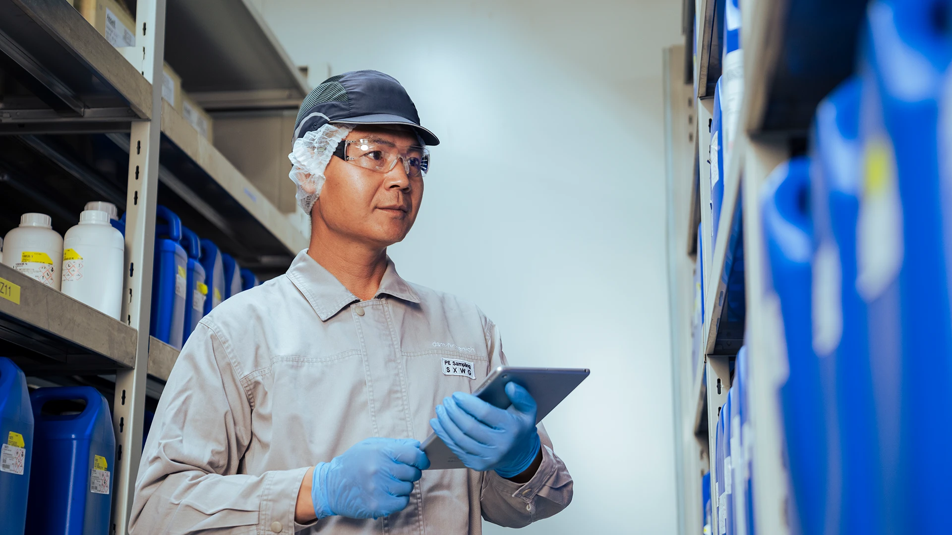 A worker inspecting inventory with a tablet, representing precision, safety, and quality control. (photo)