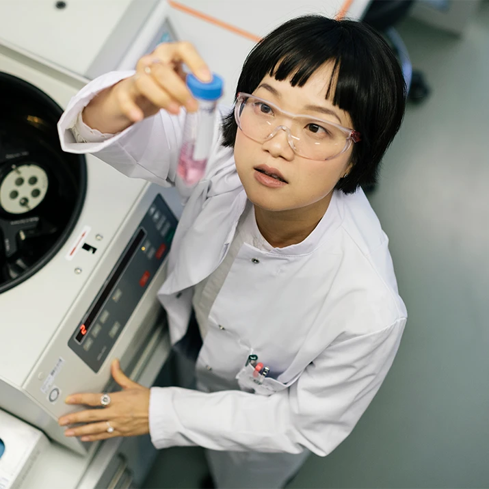 Scientist holding a sample tube in a laboratory. (photo)